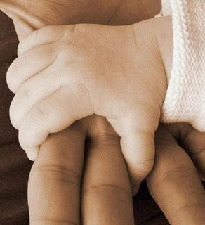 Imagen de la mano de un bebe cogiendo la de un adulto