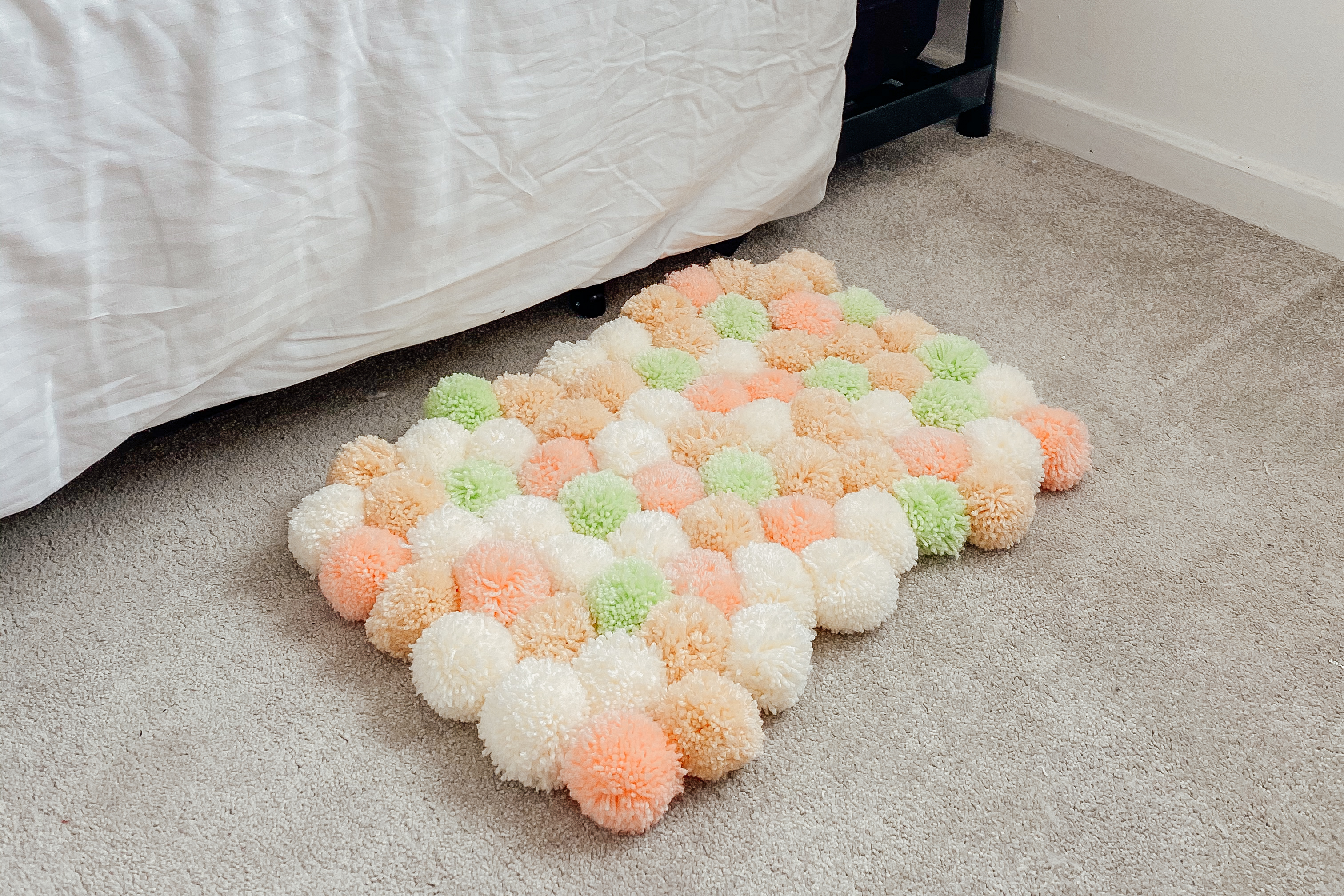 Pom-pom rug next to a bed