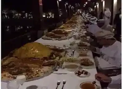 رجال عرب يأكلون على مائدة عامرة بما لذ وطاب من الأكل