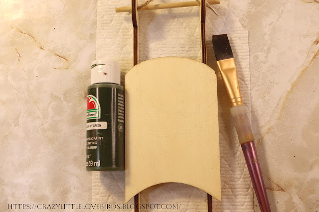 Acrylic paint, paintbrush and wooden sled