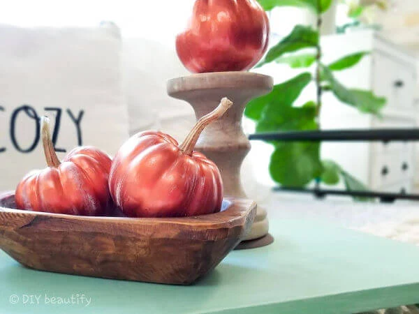 copper painted pumpkins in wood dough bowl