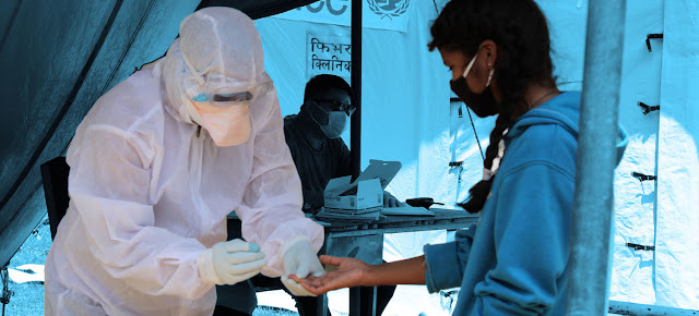 Una trabajadora de salud hace la prueba del COVID-19 a una niña en Nepal.© UNICEF Nepal