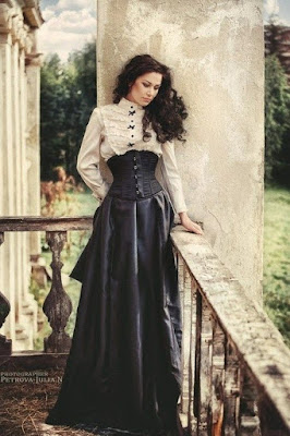 An example of an underbust corset used in steampunk victorian women's fashion. This woman wears her underbust corset with a ruffled high neck blouse and long black skirt.