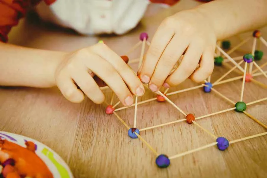 a child building a geometric figure, canva pro stock image