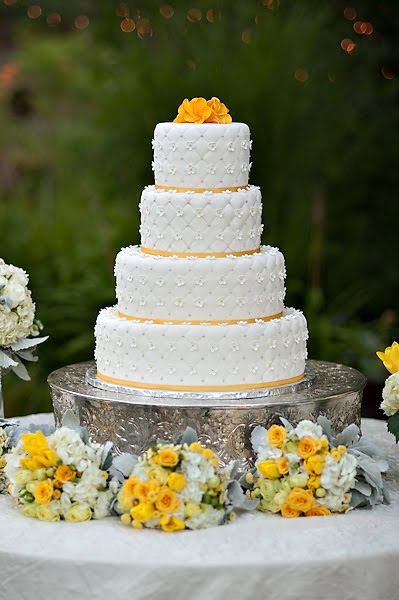 Square four tier wedding cake in white and bright yellow