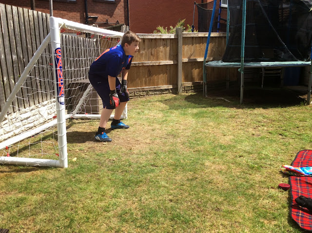 Child playing in the garden with a football