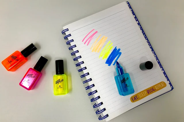 The 4 highlighter pens which look like Neon nail polish in orange, pink, yellow and blue on top of an open page in the blogger's journal