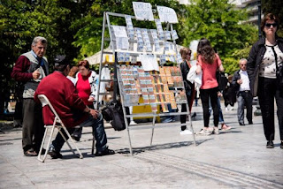 Λαχειοπώλης πάνω στον οδηγό διέλευσης τυφλών