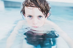 Picture of a boy in the pool looking pensive. This article is about Trauma Informed Practice in Aquatics