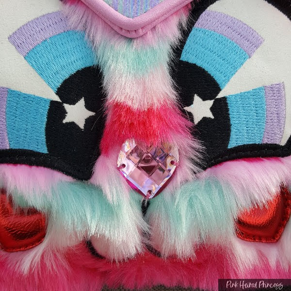 close up of striped fur, embroidered and jewelled cat face on handbag