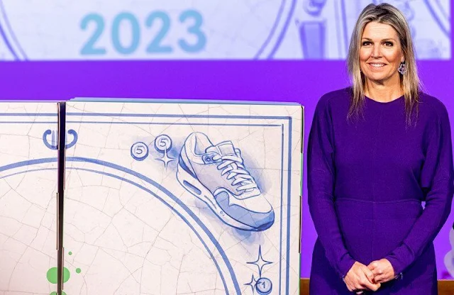Queen Maxima wore a blue dress by Victoria Beckham, and a camel wool coat. The Queen  is honorary chair of the Money Wise platform