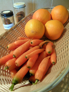 Basket of Carrots and Oranges with Spice Jars in Background
