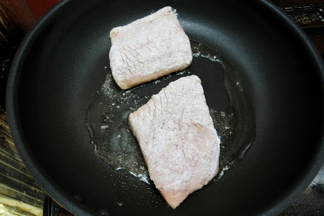 【調味料】に浸けておいた鮭に片栗粉をまんべんなくまぶします。 浸けておいた【調味料】は捨てずにとっておきます。  フライパンに油をまわし入れ、鮭を並べ入れてから中火にかけ、両面こんがり焼きます。