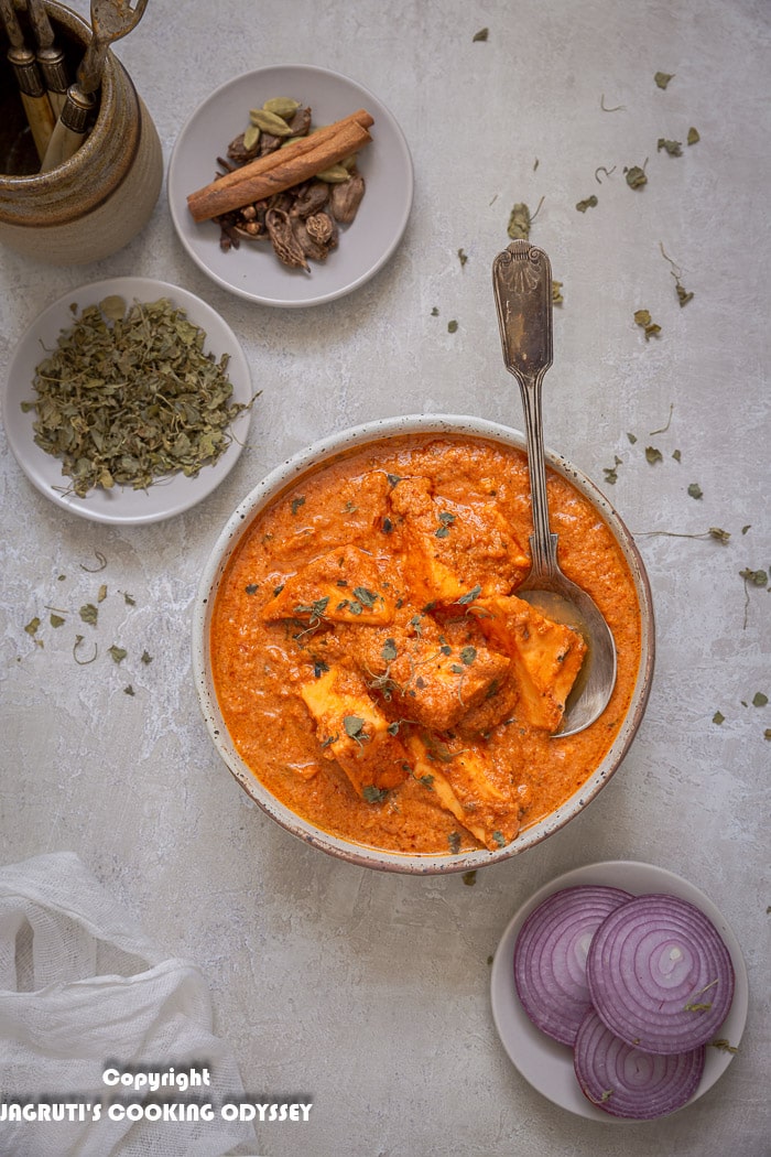 Over the head shot of paneer tikka masala curry in a bowl with spoon