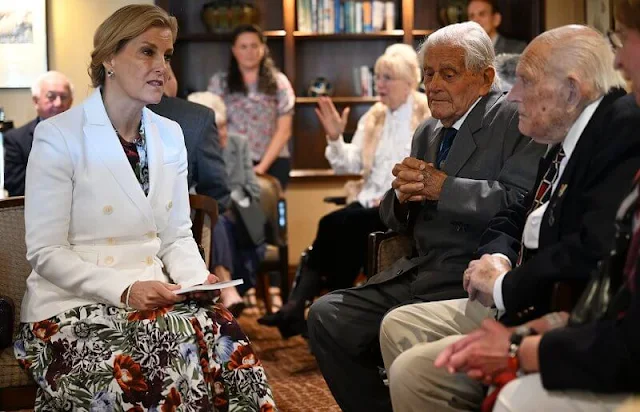 Countess of Wessex wore a white indiana jacket by Altuzarra, and a Kasia floral print dress by Erdem, a green satin silk shirt midi dress