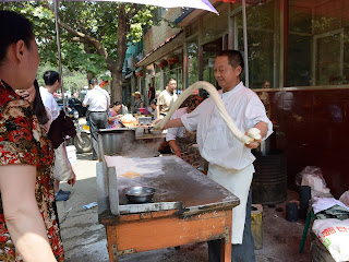 Making noodles at the Fahaisi street market in Beijing