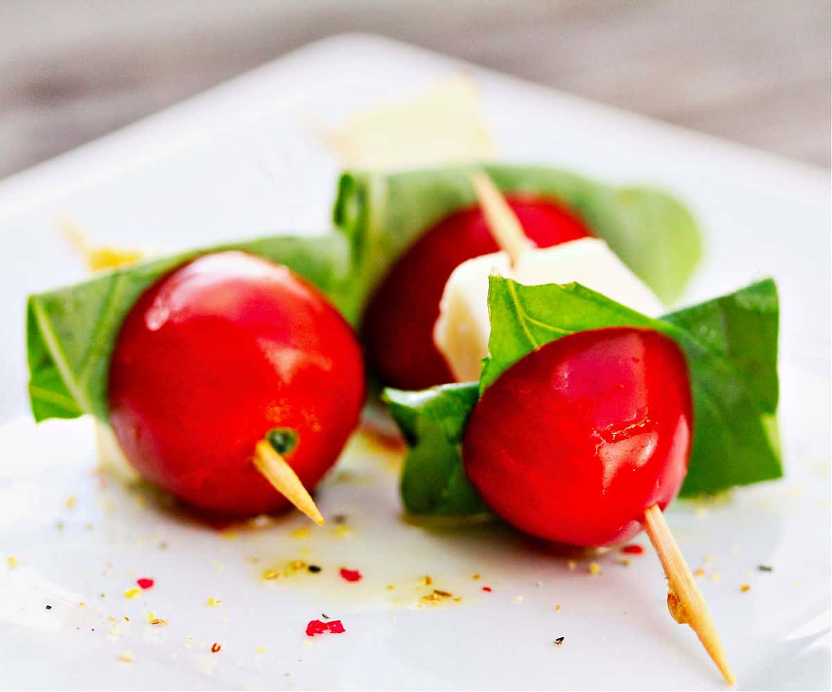 Mini Caprese Salad Skewers laying down on a plate.