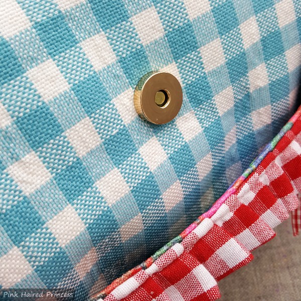 close up of stud fastening on gingham fabric handbag