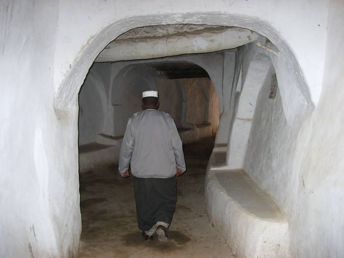 Ghadames, known as the “pearl of the desert”, is an oasis town in the Nalut District of the Tripolitania region in southwestern Libya. It is one of the oldest pre-Saharan cities and an outstanding example of a traditional settlement. The town has a population of around 10,000, mainly Berbers, who live in tightly clustered traditional mud-brick-and-palm houses, packed together like a honeycomb. The houses have a typical vertical architecture - the ground floor is used to store supplies, then another floor for the family, and at the top, open-air terraces are reserved for the women. Rooftop walkways allow women to move freely, concealed from men’s view. Overhanging structures cover the alleys between houses creating an almost underground network of passageways.