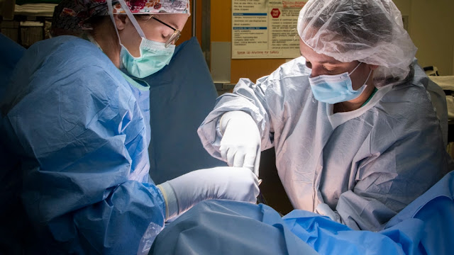 Two doctors perform surgery. Gynecologic diseases can exact substantial human, readiness, and economic tolls on the military because women currently comprise about 15% to 20% of the U.S. military, and there are about 2 million female veterans.  (Credit: U.S. Army photo by Jason W. Edwards)