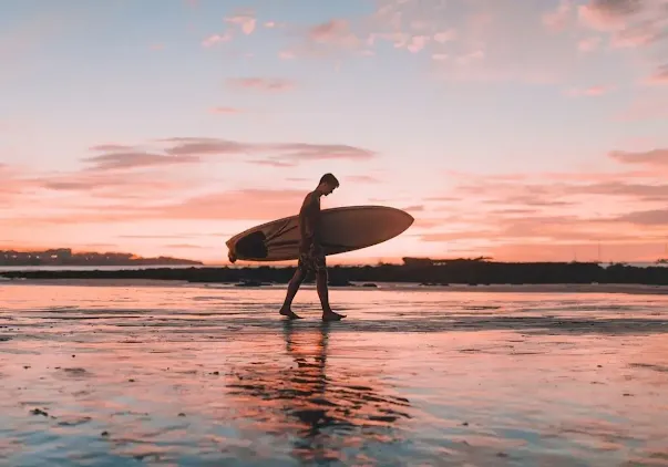 A surfer walking on evening at Tourmaline Surfing Park