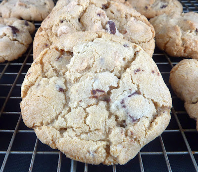 A variation on chocolate chip cookies: cookies with dark chocolate chunks and peanut butter chips, photographed on a wire cooling rack