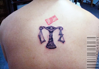 a Libra tattoo design variation on the back with girlfriend's initial on the two sides of the scale