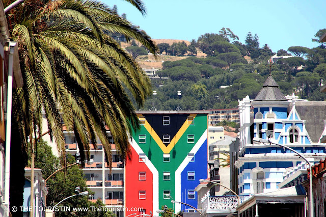 Red, white, green, yellow, black, blue South African Flag on a house facade.