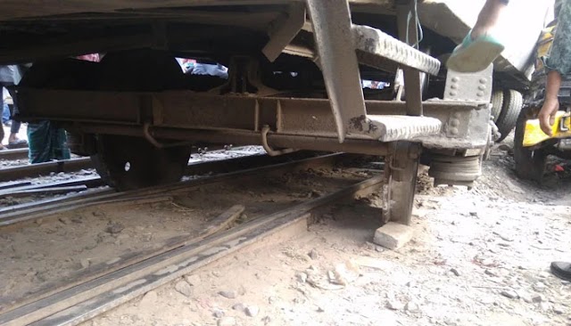 Another truck pushes the wrecked truck into the train