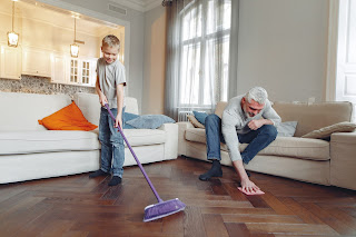 An elderly man and his grandchild cleaning together.
