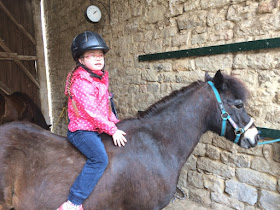 Jolina, Down Syndrom, auf einem Pony