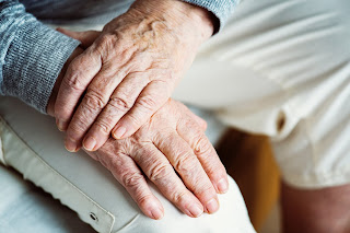 Elderly man massaging wrist