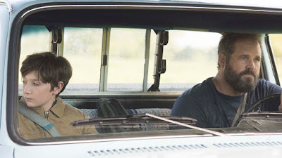 David Denman drives Jackson A. Dunn around in his truck in a movie still for the film Brightburn (2019)