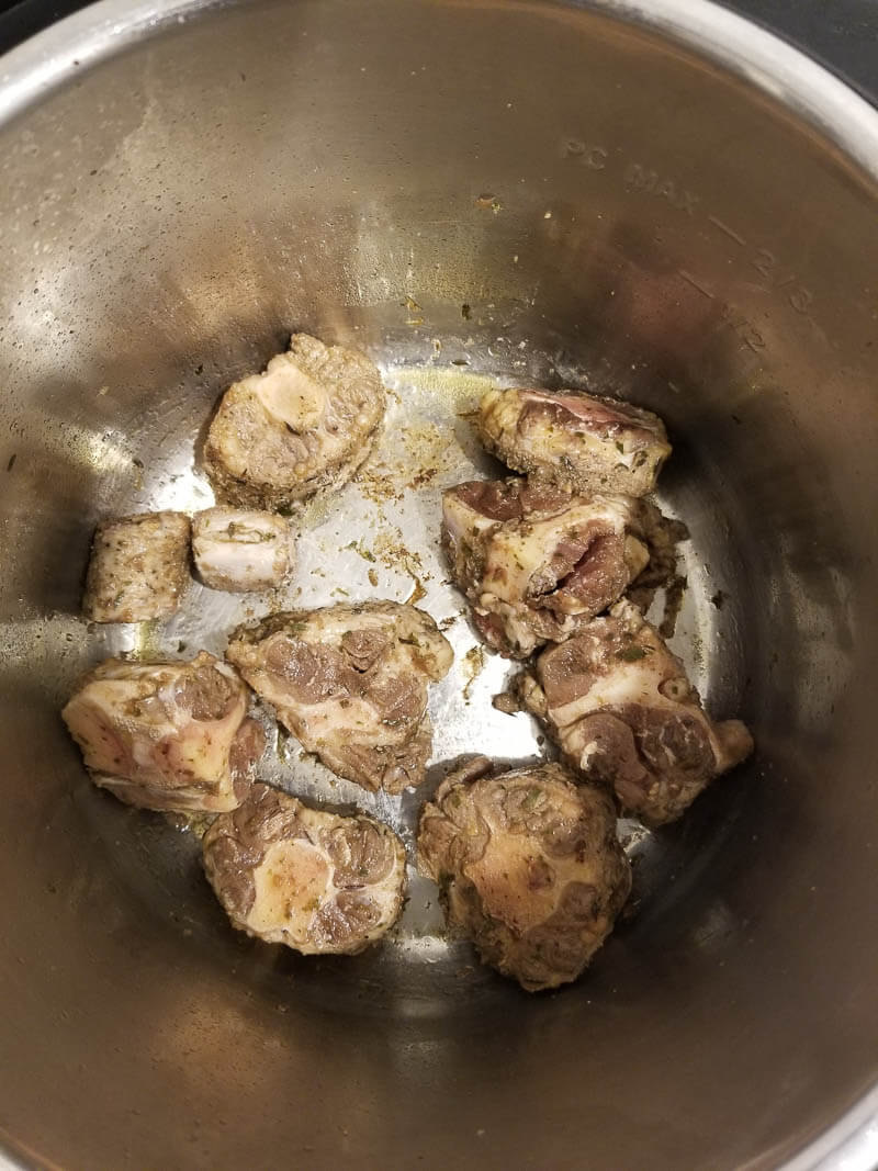 Oxtail being braised in the pot before adding it to soup.