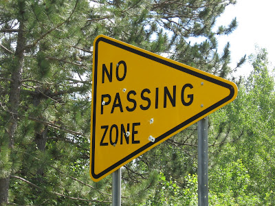 Redneck country - bullet holes in a No-Passing road sign