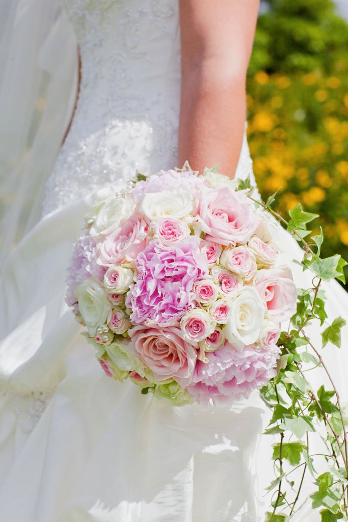 Pink peonies mixed roses and trails of ivy make a lovely wedding bouquet 