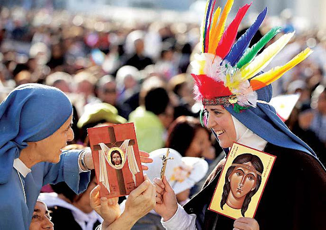 Two nuns hold images of Kateri Tekakwitha, the first Native American to achieve sainthood, at the Vatican, on Sunday