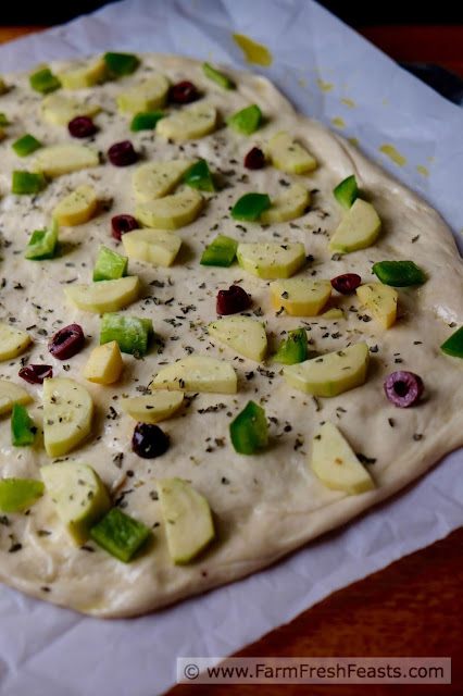 This pizza is a vegetarian's Late Summer Dream. Squash, peppers, olives and slow-roasted tomatoes covered with cheese.