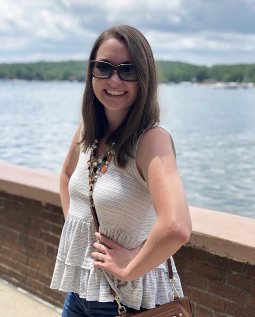 Model is wearing blue, white, and saddle-colored outfit with pieces from popular women's clothing stores in Lake Geneva.