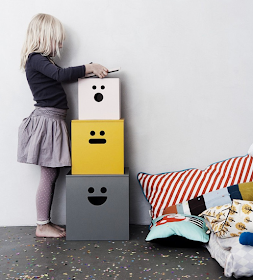 three plywood storage boxes with faces painted on them