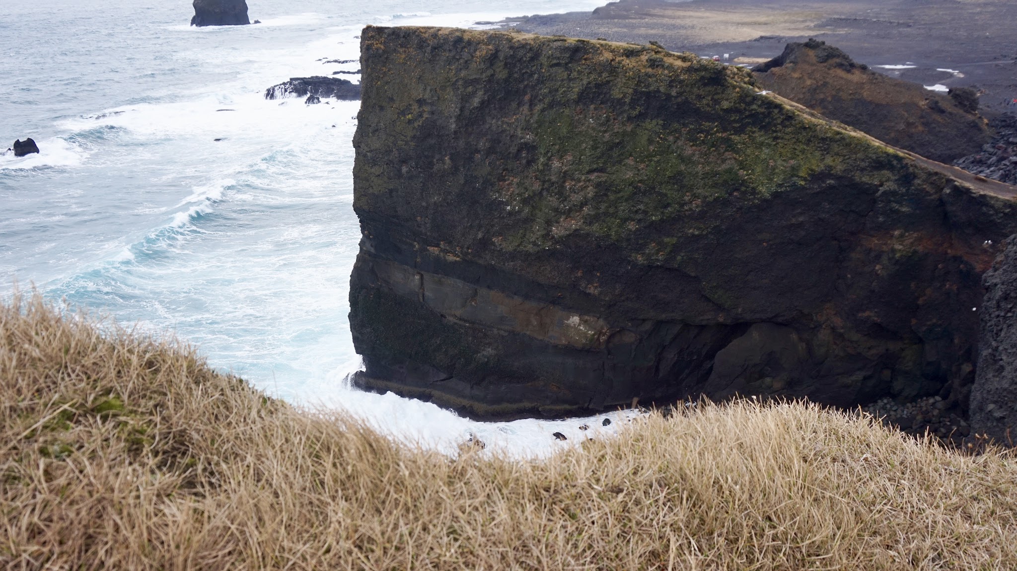 black cliffs overlooking choppy icy blue waves