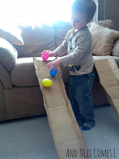 J putting wobbly Easter eggs on to a cardboard ramp from And Next Comes L