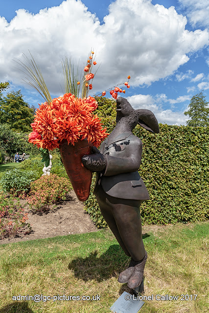 A large rabit about six foot tall with a bunch of red flowers