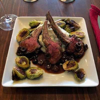 Herb crusted rack of lamb with herb mashed potatoes and red wine reduction, with oven roasted Brussels sprouts