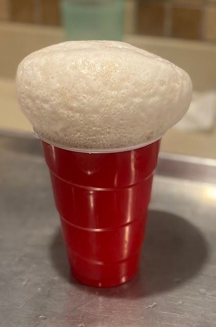 Elephant toothpaste rising above red solo cup