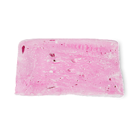 A bright pink trapezoid shaped piece of solid body wash that looks like marshmallow on a bright background