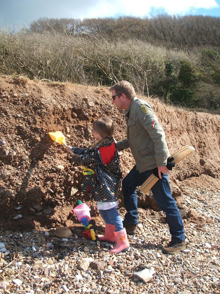 child and father search for pebbles and fossils in sandbanks