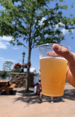 A Schöfferhofer Prickly Pear Hefeweizen held up with Spaceship Earth in the background