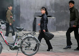 People walk past an electric bicycle in Pyongyang, North Korea May 6, 2016.