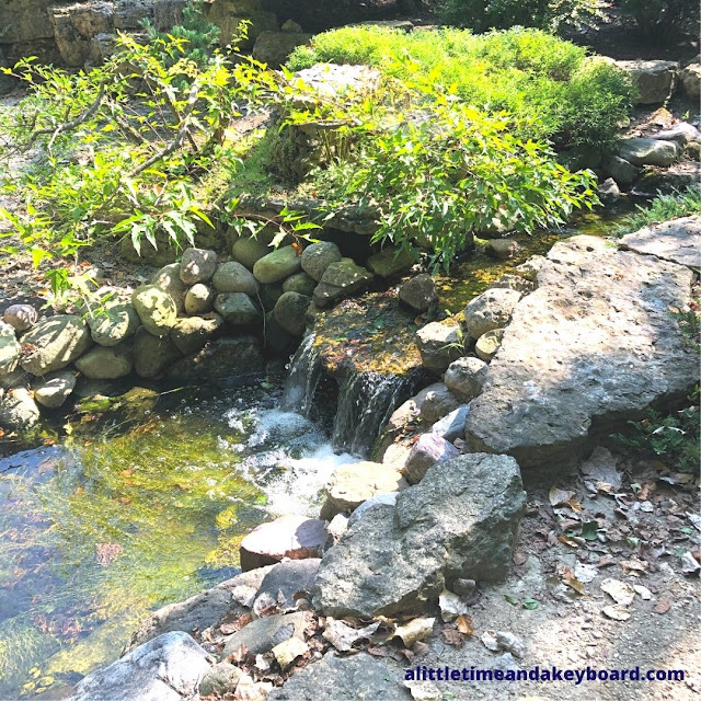 A waterfall tranquilly flows in the Japanese garden.